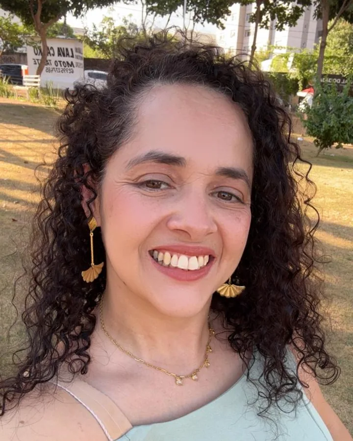 Maria Campos, a Mary, fundadora da Mary Gifts, sorrindo ao ar livre em um fim de tarde de sol